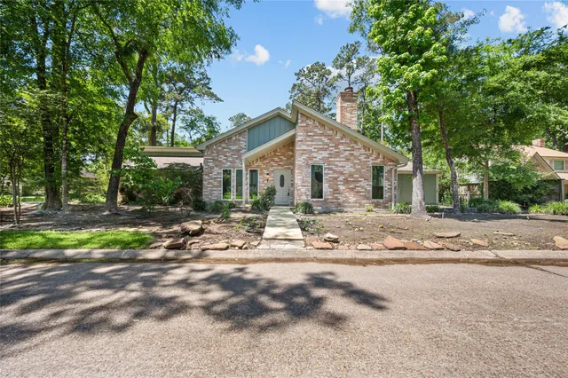 a view of a house with backyard and trees