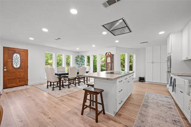 a large white kitchen with lots of counter space and furniture