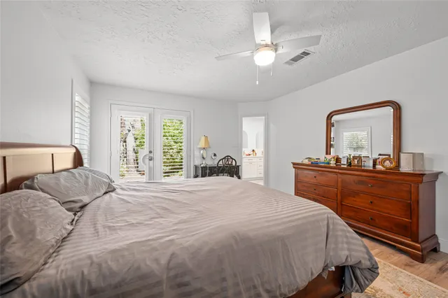 a bedroom with a bed and a large mirror on dresser