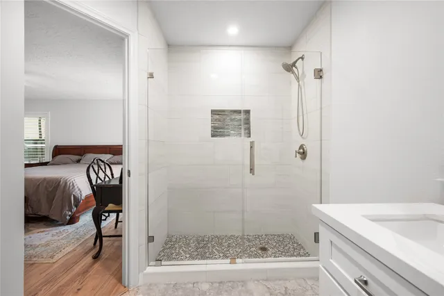 a bathroom with a granite countertop sink a toilet and shower
