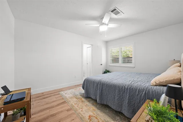 a bedroom with a bed and wooden floor