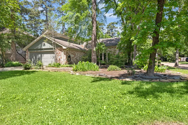 a front view of a house with a yard and trees