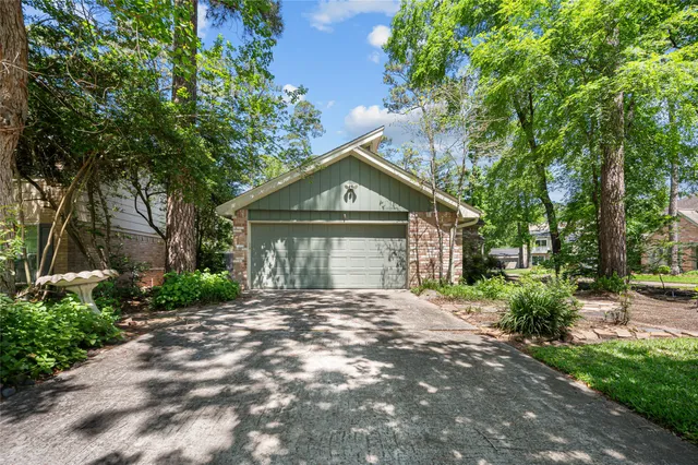 a front view of a house with a garden and trees