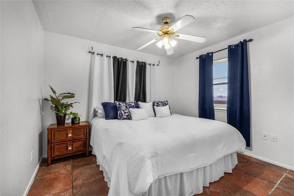 748 Rocky Ridge Lane Weatherford, TX 76085 - Photo 16 of 38 a bedroom with a bed and a chandelier