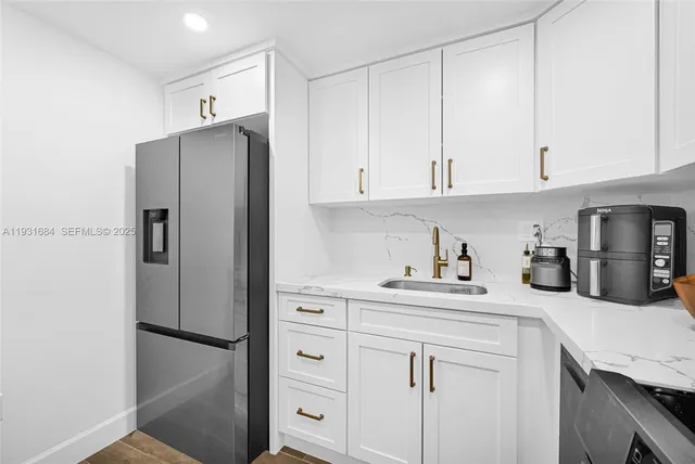 a kitchen that has a sink and a stove with wooden floor