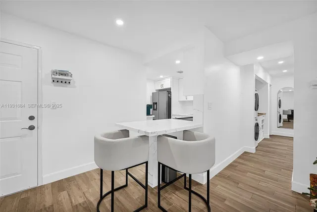 a living room with furniture and a kitchen island with wooden floor