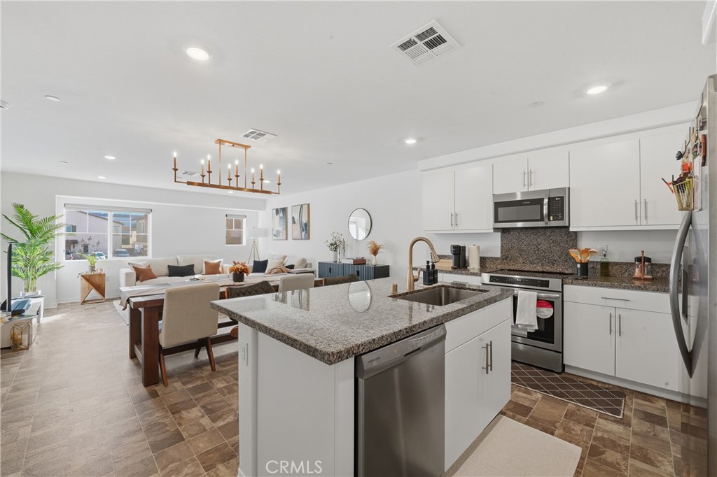 19210 Ash Grv Street Riverside, CA 92507 - Photo 14 of 38 a kitchen with a sink stove and cabinets