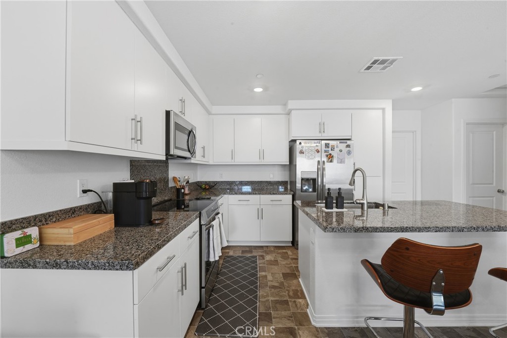 19210 Ash Grv Street Riverside, CA 92507 - Photo 15 of 38 a kitchen with stainless steel appliances granite countertop a sink stove and cabinets