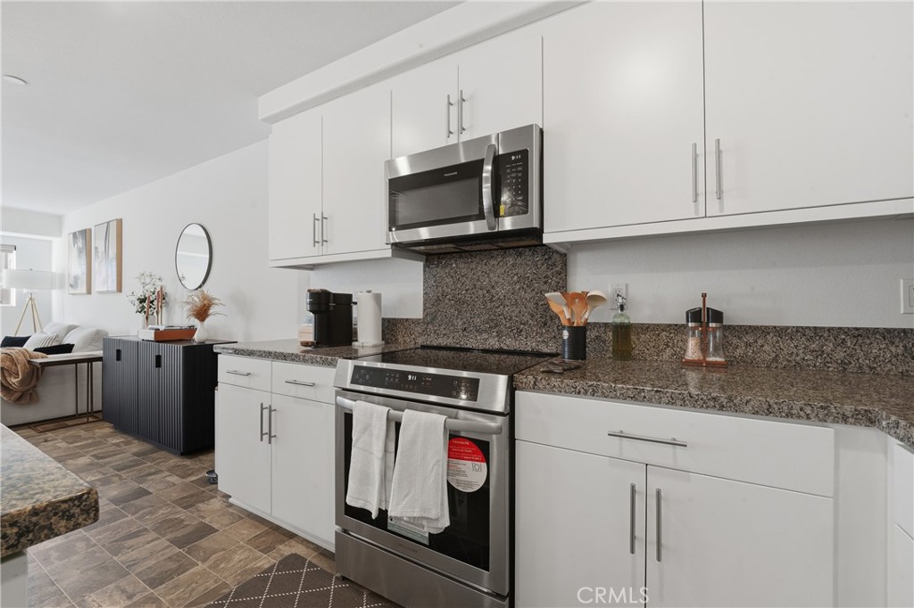 19210 Ash Grv Street Riverside, CA 92507 - Photo 17 of 38 a kitchen with stainless steel appliances granite countertop a sink and a stove