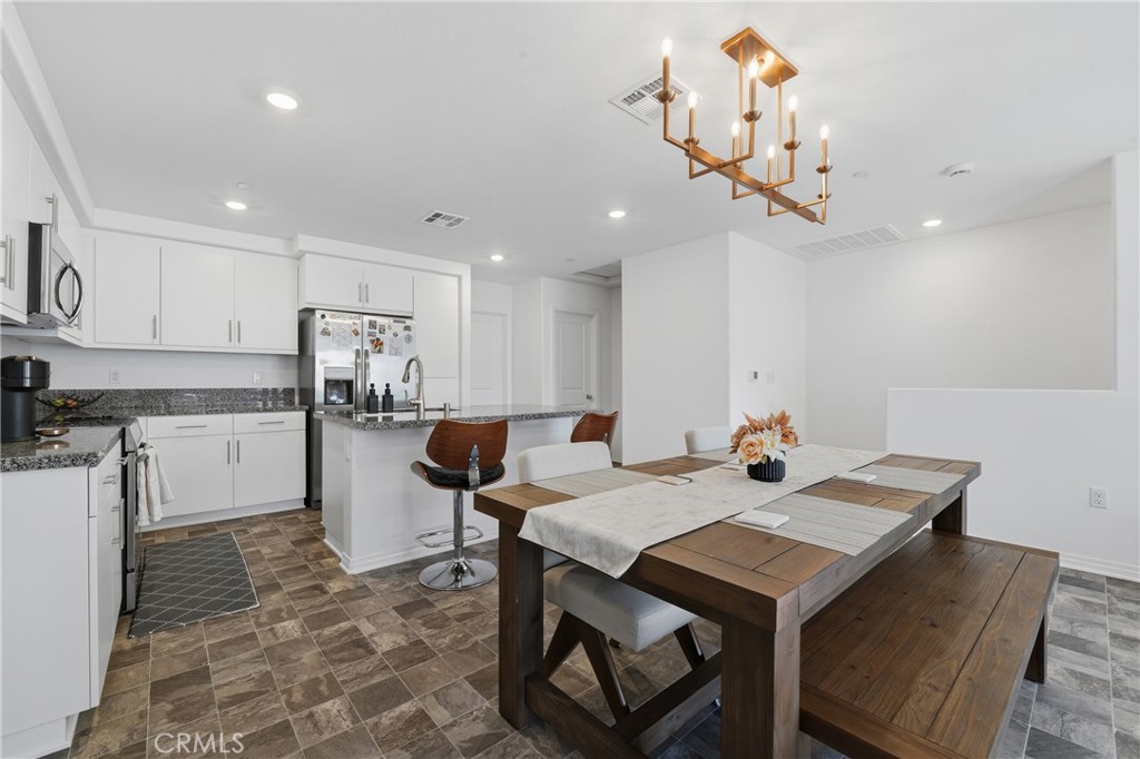 19210 Ash Grv Street Riverside, CA 92507 - Photo 8 of 38 a kitchen with kitchen island a dining table and chairs