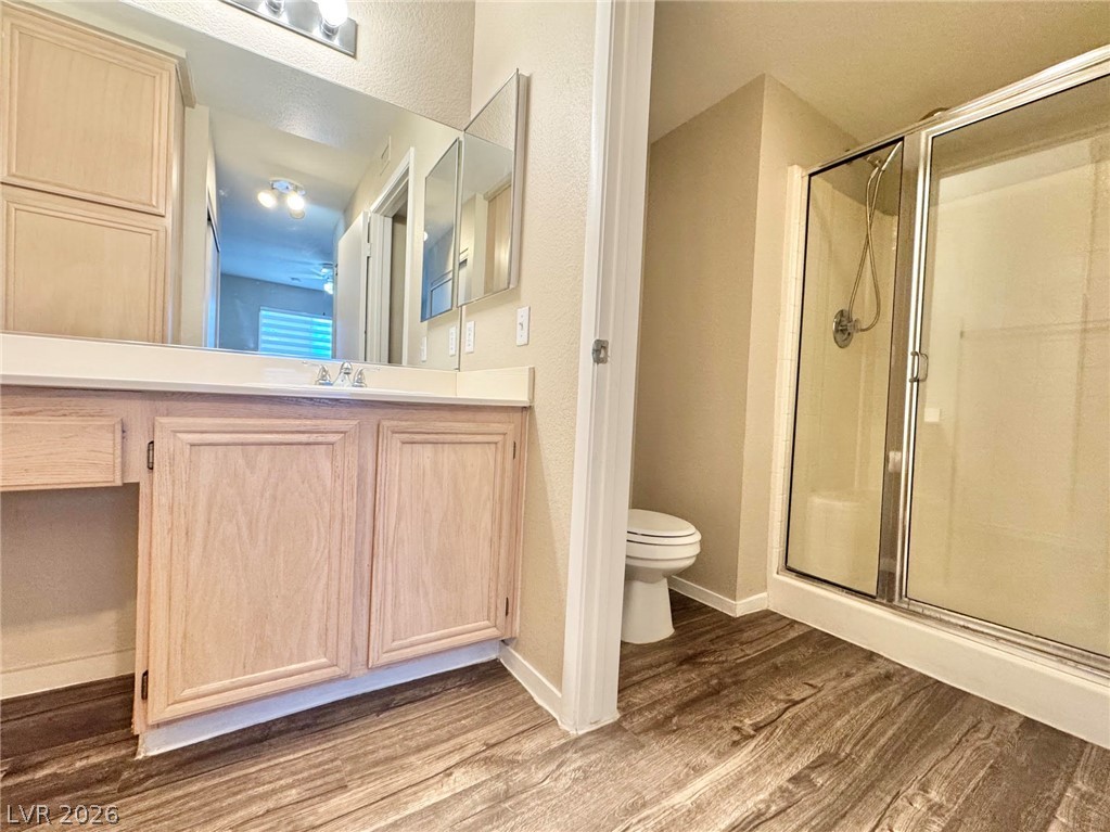 8070 West Russell Road, Unit 2121 Las Vegas, NV 89113 - Photo 17 of 22 A functional bathroom boasts a vanity, toilet, and a convenient shower stall.