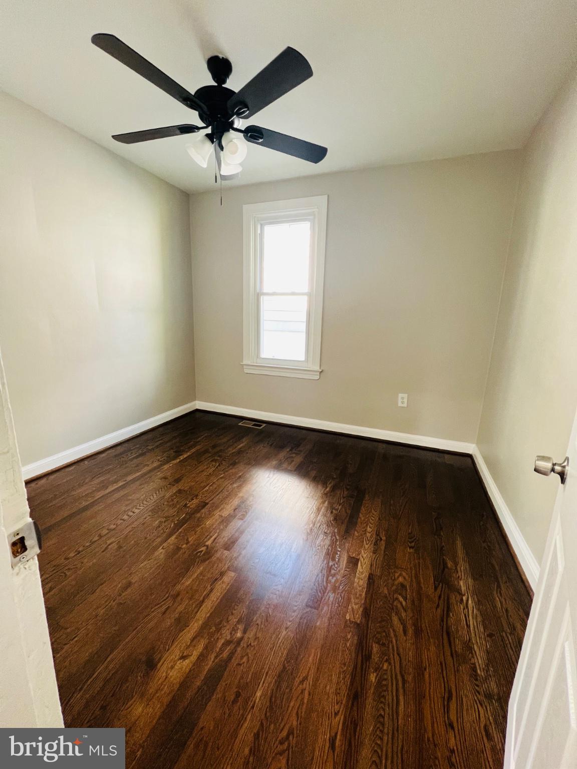 5709 Dade Street Capitol Heights, MD 20743 - Photo 23 of 30 an empty room with wooden floor chandelier fan and windows