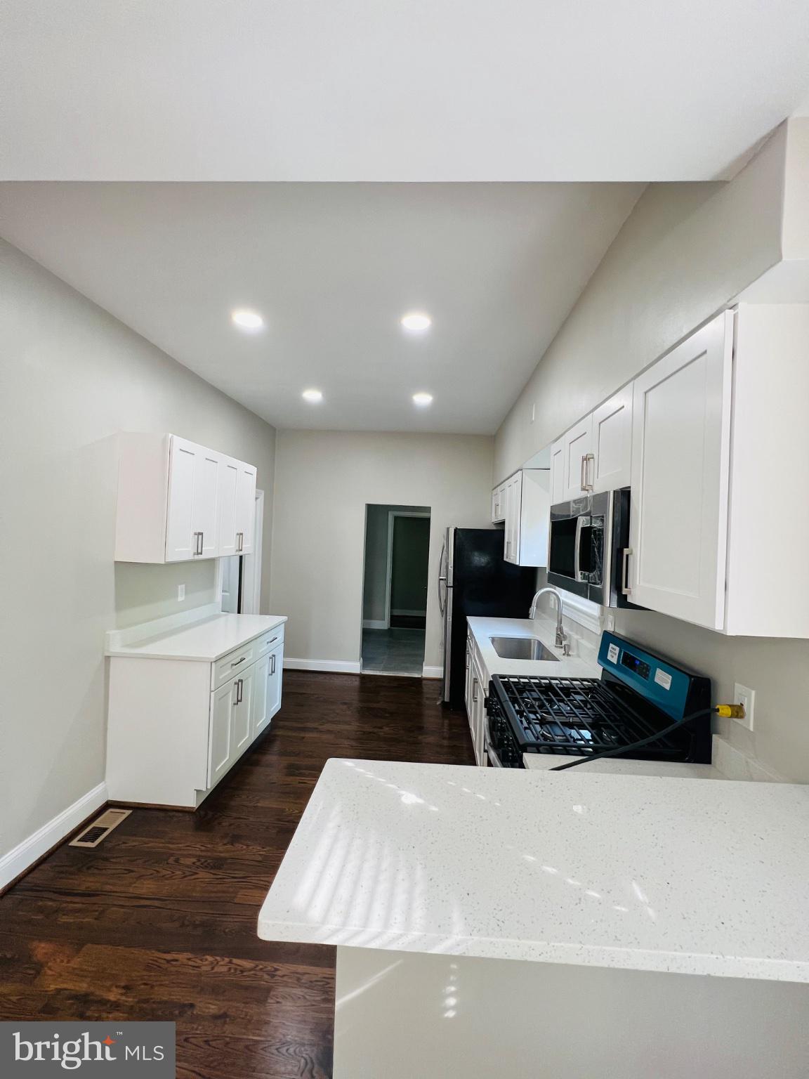 5709 Dade Street Capitol Heights, MD 20743 - Photo 24 of 30 a large white room with kitchen island a stove a sink dishwasher and a stove