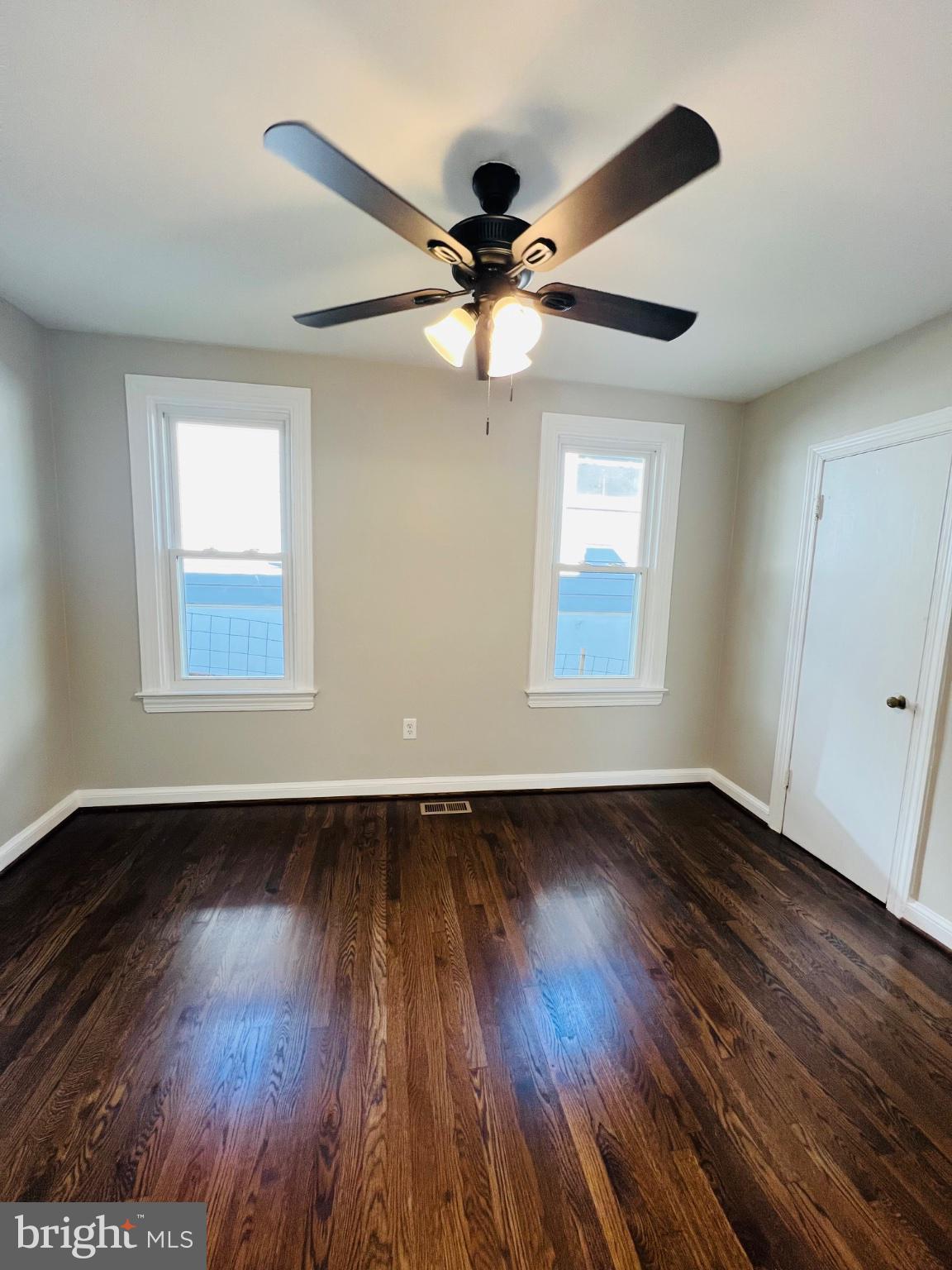 5709 Dade Street Capitol Heights, MD 20743 - Photo 26 of 30 an empty room with wooden floor ceiling fan and windows