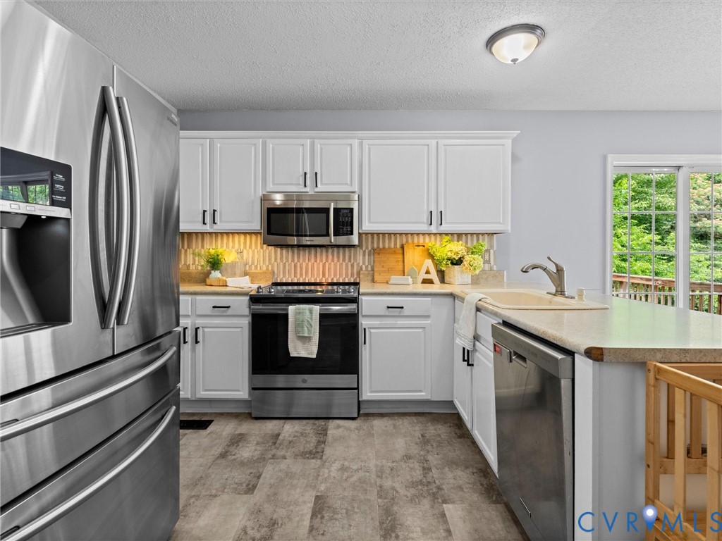 6712 Hedges Road Richmond, VA 23224 - Photo 12 of 34 Modern kitchen featuring white cabinetry, stainles