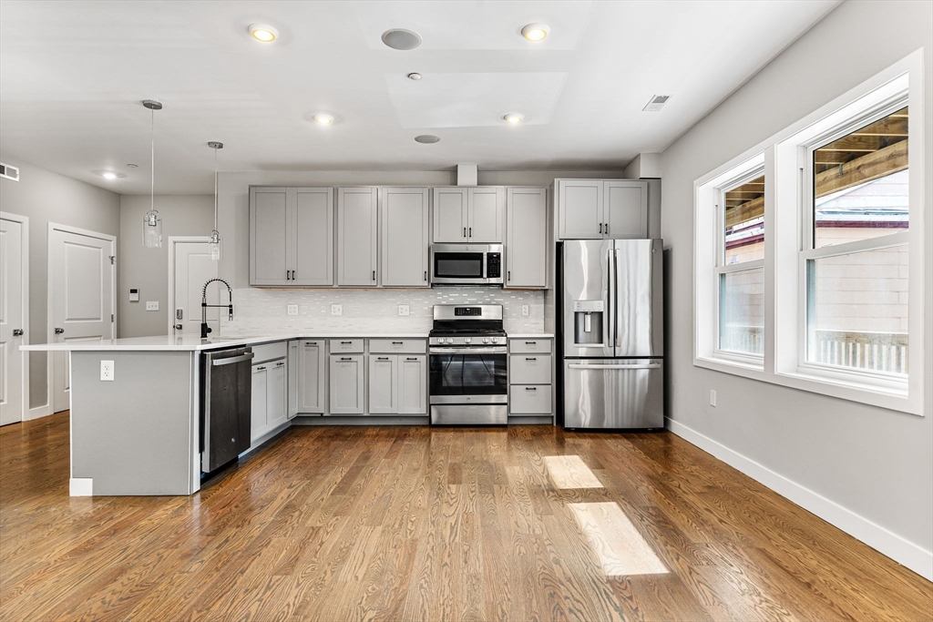a kitchen with stainless steel appliances a refrigerator sink a microwave and cabinets