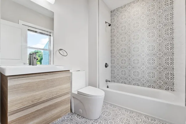 a bathroom with a bathtub sink vanity mirror and toilet
