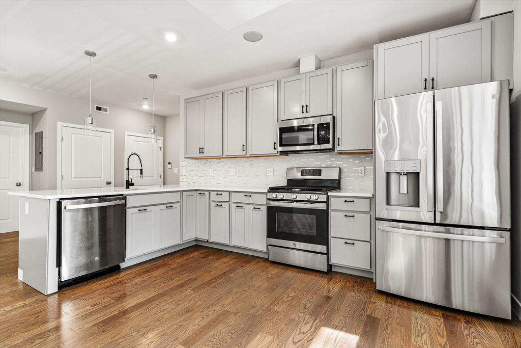 10 Ruthven Park, Unit 2 Boston, MA 02121 - Photo 10 of 25 a kitchen with granite countertop white cabinets and stainless steel appliances