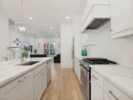 a kitchen with a sink a stove and cabinets