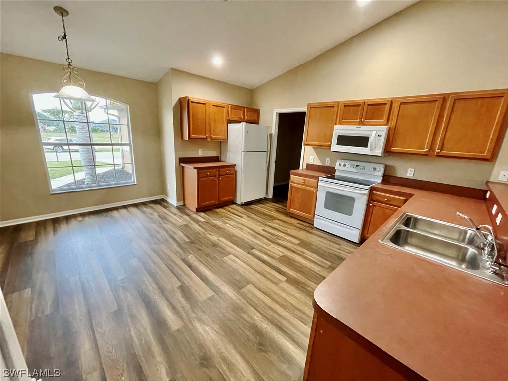 2804 Nelson Road North Cape Coral, FL 33993 - Photo 6 of 16 a open kitchen with wooden floor and stainless steel appliances