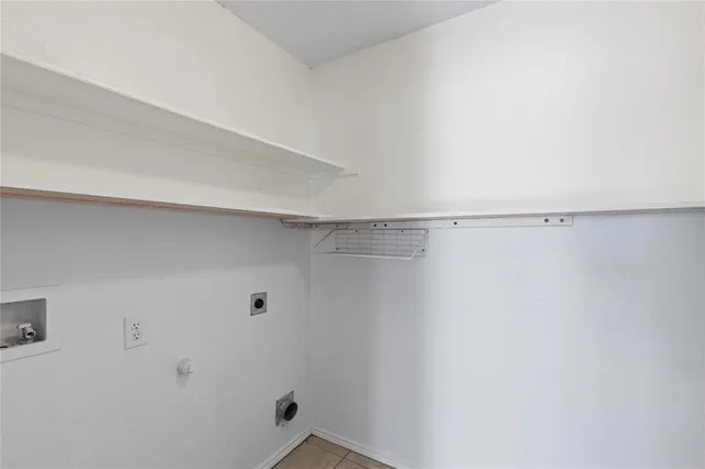 a view of an empty room with wooden floor fireplace and a window
