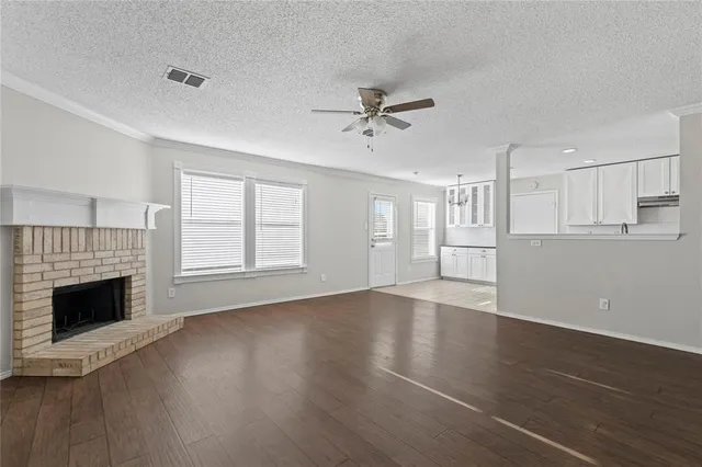 an empty room with windows and a fireplace