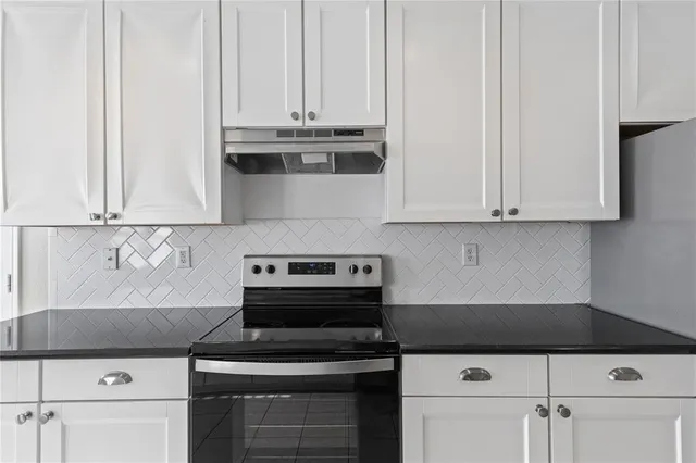 a kitchen with stainless steel appliances a sink stove and cabinets