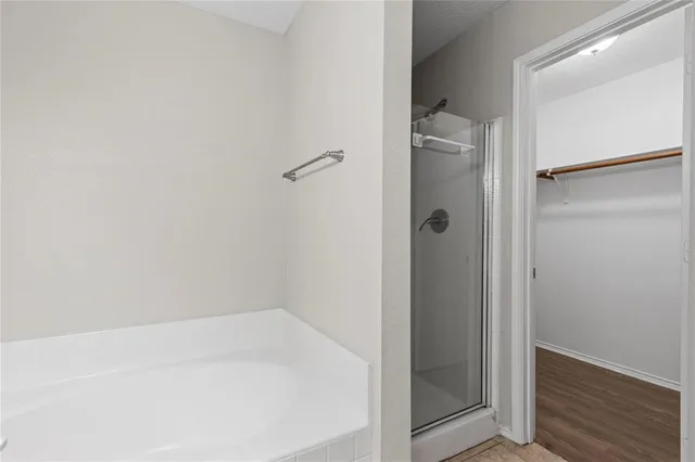 a bathroom with a tub a sink and mirror