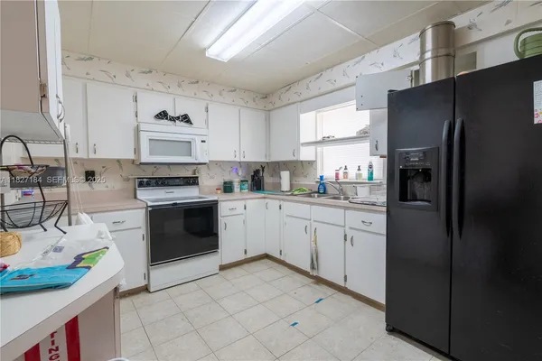 a kitchen with stainless steel appliances a refrigerator sink stove and cabinets