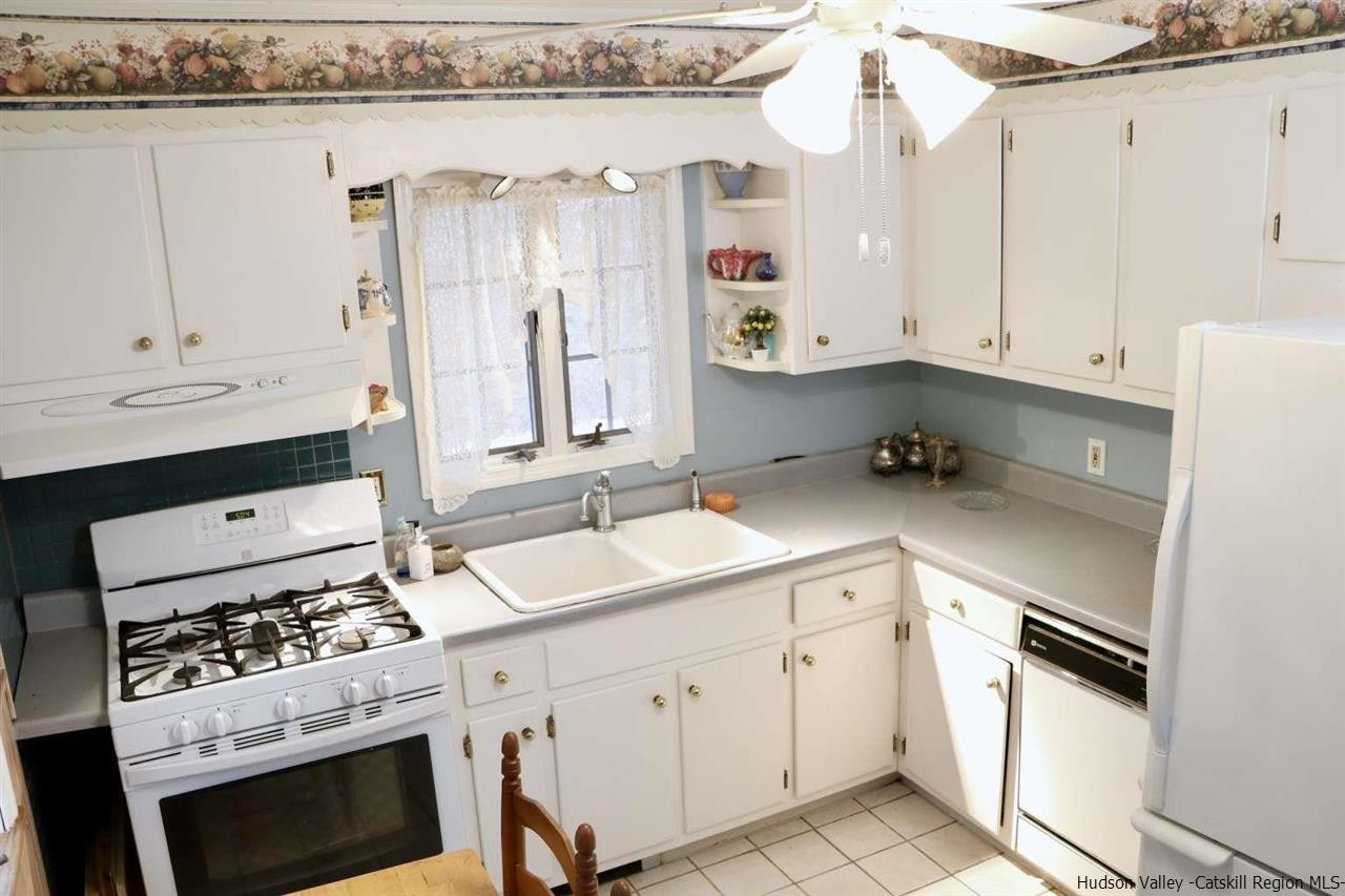 99 Grist Mill Road Tillson, NY 12486 - Photo 3 of 6 a kitchen with granite countertop a sink a stove and cabinets