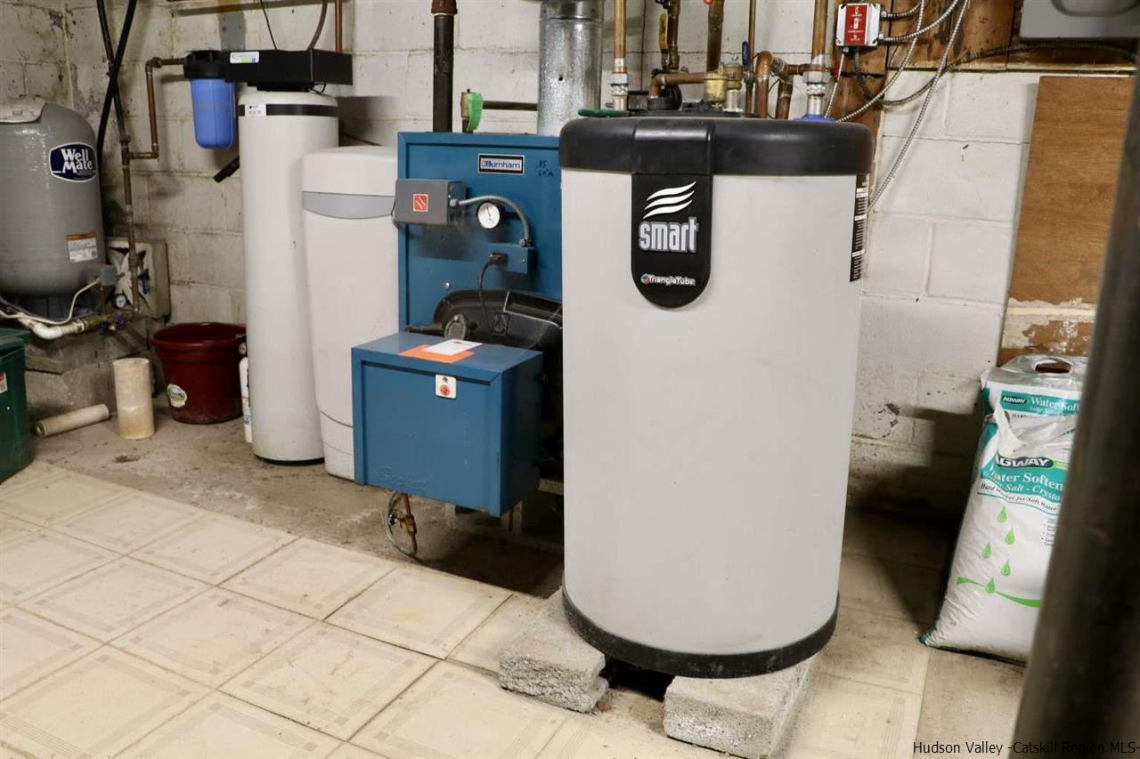99 Grist Mill Road Tillson, NY 12486 - Photo 5 of 6 a room with water heater and wooden cabinets