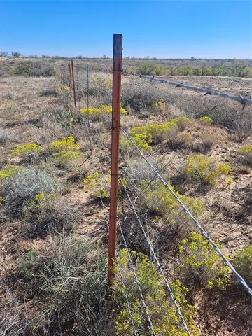 a view of a yard with wooden fence