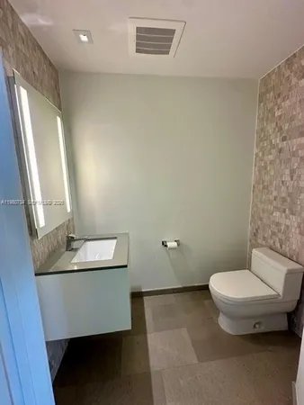 a large white kitchen with granite countertop a stove top oven a sink and dishwasher with wooden floor