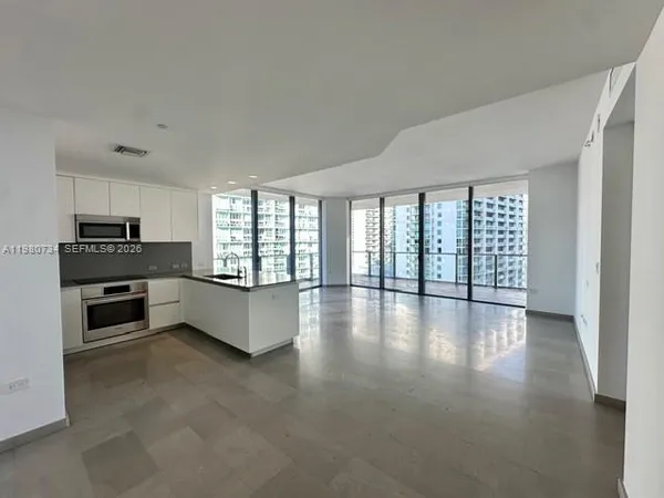 a view of a kitchen with a sink and a refrigerator