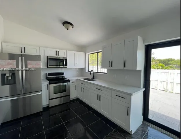 a kitchen with a sink appliances and cabinets
