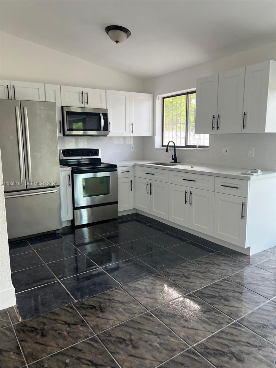 14013 Southwest 281st Terrace Homestead, FL 33033 - Photo 3 of 10 a kitchen with stainless steel appliances a stove a sink and a refrigerator