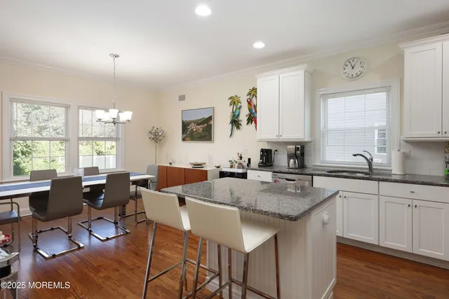 a large kitchen with kitchen island granite countertop a sink and cabinets