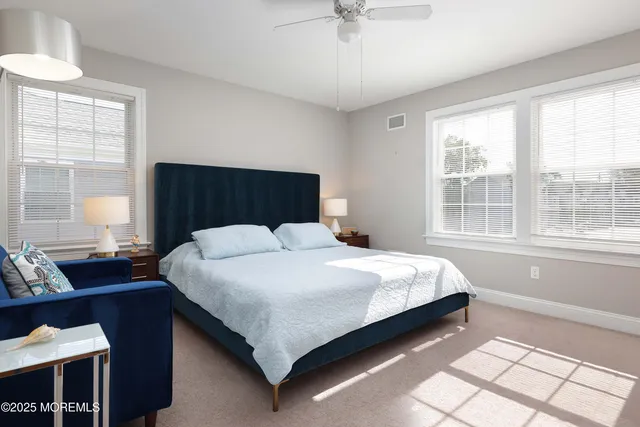 a large bed sitting in a bedroom next to a window
