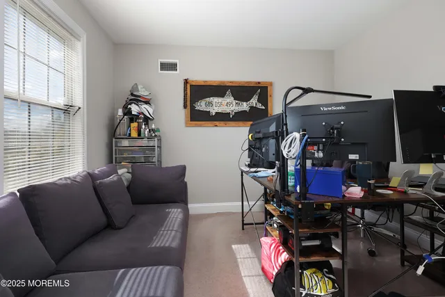 a living room with furniture a flat screen tv and a window