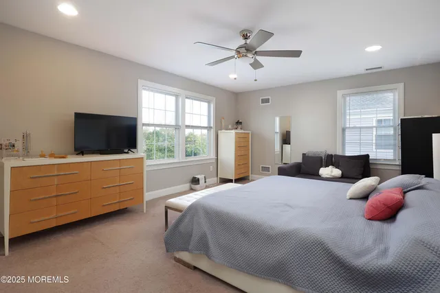 a bedroom with bed tv and window