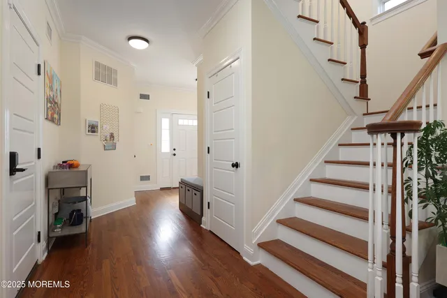 a view of entryway with wooden floor and stairs