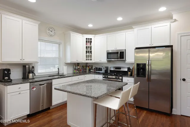 a kitchen with a sink a microwave a refrigerator and cabinets