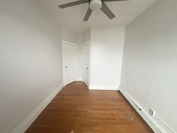 a view of empty room with wooden floor
