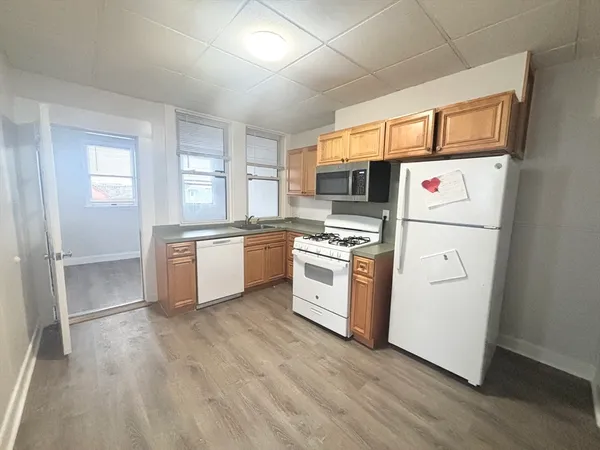 a kitchen with white cabinets and white appliances