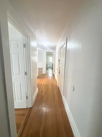 a view of a hallway with wooden floor