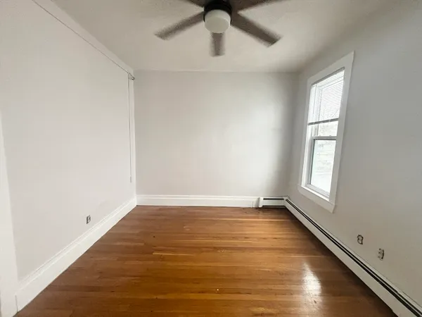 wooden floor in an empty room with a window