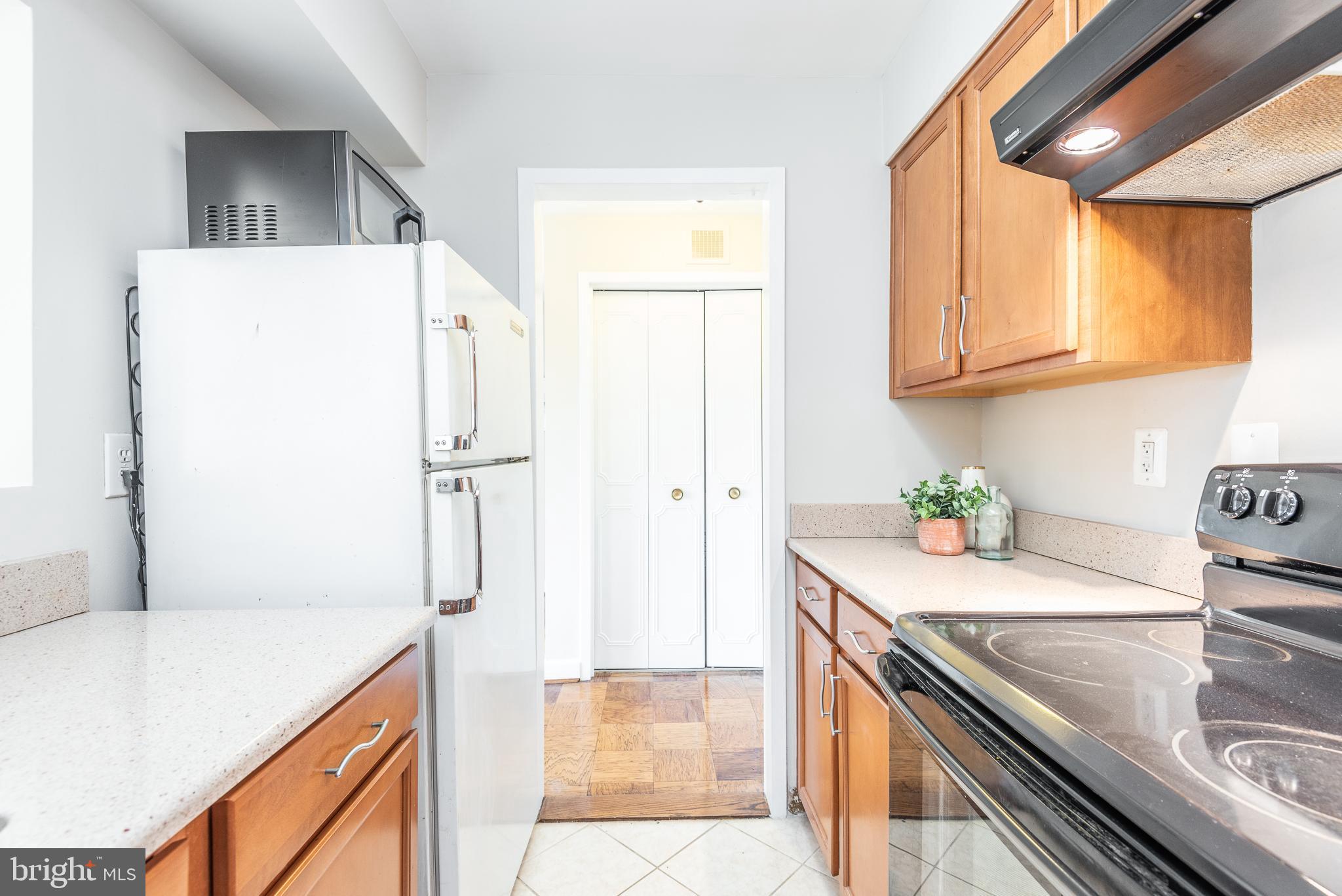 2501 Calvert Street Northwest, Unit 811 Washington, DC 20008 - Photo 7 of 28 a kitchen with stainless steel appliances granite countertop a refrigerator a sink a stove and white cabinets
