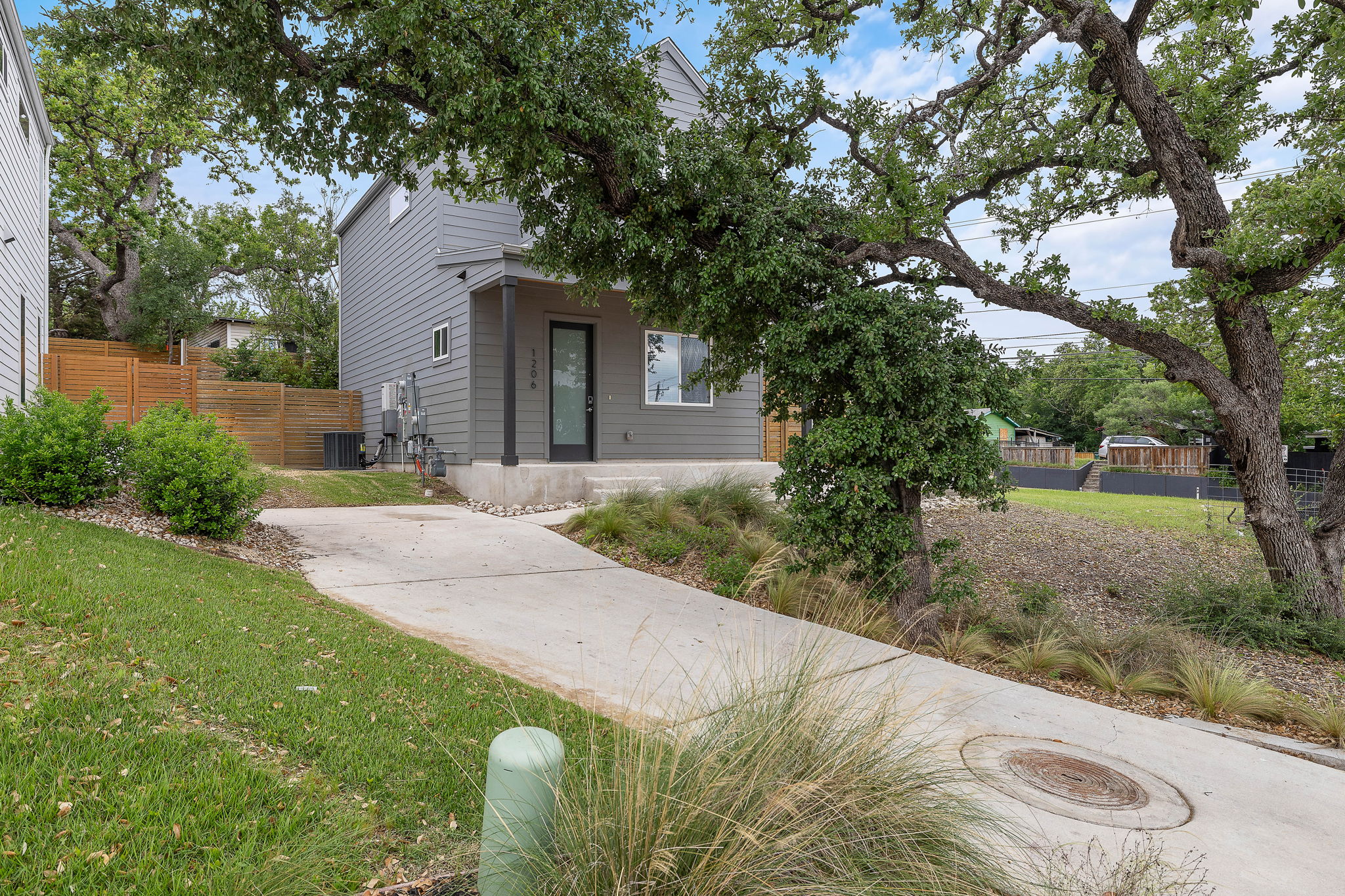 1206 Sarabeth Way Austin, TX 78721 - Photo 4 of 27 View of front of property with cooling unit, covered porch, a front lawn, and fence