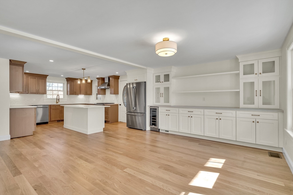 510 Common Street Walpole, MA 02081 - Photo 5 of 35 a large white kitchen with kitchen island a sink a center island and stainless steel appliances
