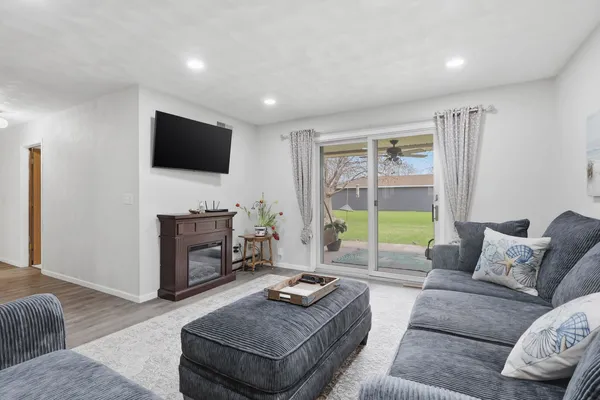 a living room with furniture a flat screen tv and a large window